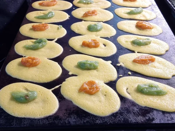 Tayland tatlıları (Tokyo tatlıları, Tokyo tatlıları, Khanom Tokyo) ve Tayland 'da sokak yemekleri için bir sobanın üzerindeki pankekler. Sarı krema dolguları ve yeşil pandan kreması dolguları var..