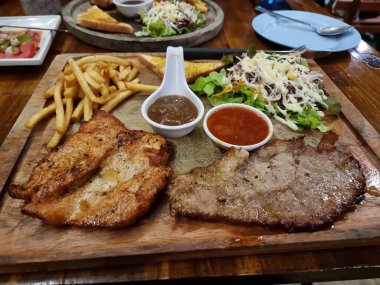 Tavuklu biftek ve ahşap bir tabakta müşterilere servis yapmak için masaya konur..