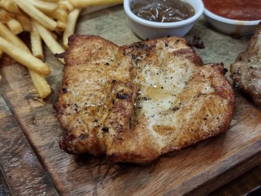 Tavuklu biftek ve ahşap bir tabakta müşterilere servis yapmak için masaya konur..