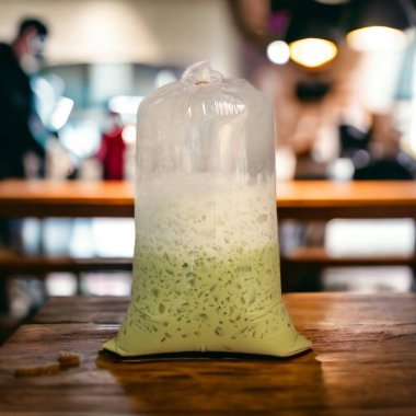 Masaya bırakılmış büyük bir torba Tayland yeşil çay sütü. Renkli bulanık arkaplan.