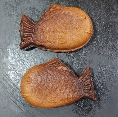 Siyah demir tavada iki Taiyaki Balığı..