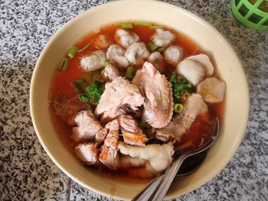 Tavuk parçaları ve çeşitli köftelerle zengin pembe erişte çorbası. Lezzetli ve tatmin edici bir ana yemek..