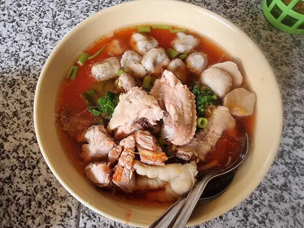 Tavuk parçaları ve çeşitli köftelerle zengin pembe erişte çorbası. Lezzetli ve tatmin edici bir ana yemek..