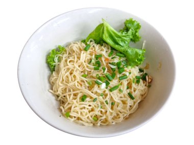 Beyaz arka planda izole edilmiş taze yeşil marul ve mis kokulu soğanla süslenmiş basit bir kase kuru yumurta eriştesi. Basit ve hafif bir yemek.