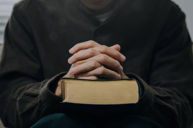 Hristiyan adam, pazar sabahı dua etmek ve Tanrı 'ya ibadet etmek için İncil okuyor. Maneviyat, din, inanç. Hristiyan hayatı. Kilisede Tanrı' nın kelamını çalışmak..