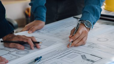 Mühendis ekipleri ofiste birlikte çalışıyor. Mühendis, mimar, endüstri ve fabrika konsepti. Bina planı, miğfer, sanayi mimarı, profesyonel ekip ve fabrika..