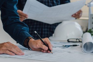 Mühendis ekipleri ofiste birlikte çalışıyor. Mühendis, mimar, endüstri ve fabrika konsepti. Bina planı, miğfer, sanayi mimarı, profesyonel ekip ve fabrika..