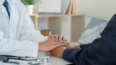 Sağlık bakımı kavramı. Doktor el ele tutuşur, empati, rahatlık, psikolojik destek verir, ciddi hastalık teşhisini açıklar..