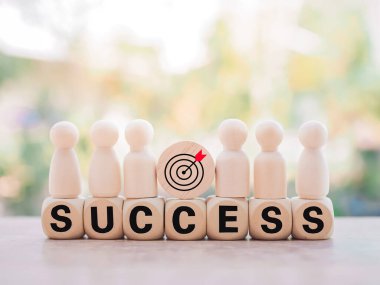 Tahta bloklarda duran tahta figür, başarı ve kazanma konsepti için iş stratejisi simgeleri ve SUCCESS sözcüğüyle.