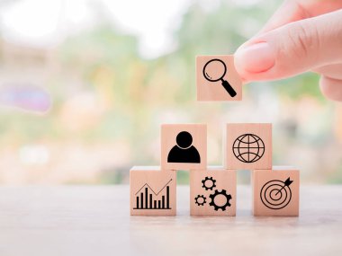 Close up hand arranging wooden block with  business strategy icons, Action plan and business process management concept.