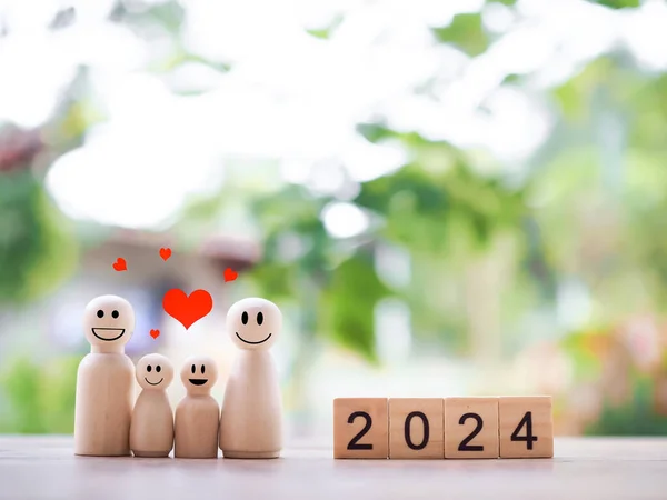 Wooden figure family happy face with heart and wooden block with number 2024. The concept of romantic feelings, family relationship.