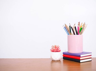 Ofis masası, renkli kırtasiyeli yaratıcı öğrenci masası, ciltli kitap, saksı kaktüsü. Metin için boşluk kopyala, okula geri dön, eğitim kavramı