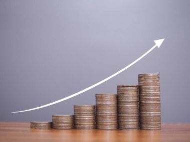 Yükselen ok simgeleriyle dolu bozuk para yığını. İş büyümesi, mali yatırım, piyasa hisseleri, kar iadesi, bölünme ve iş fonu kavramı.