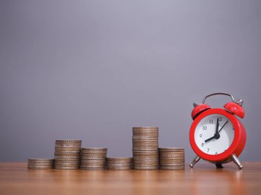 Bozuk paraların üzerindeki kırmızı alarm. İş hayatına zaman ayırmak için para biriktirme kavramı.