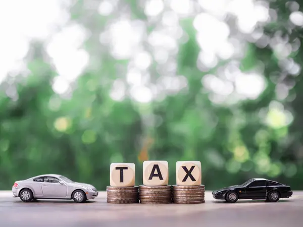 Toy cars and wooden blocks with the word TAX on stack of coins. The concept of saving and mamage money to success transportation, Paying tax and car loan