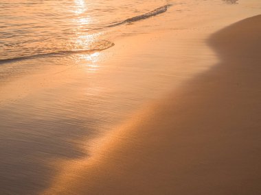 Water and sand at the beach in sunset time