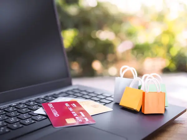 Shopping bags and Credits cards on a laptop keyboard. Concepts about online shopping that offers home delivery