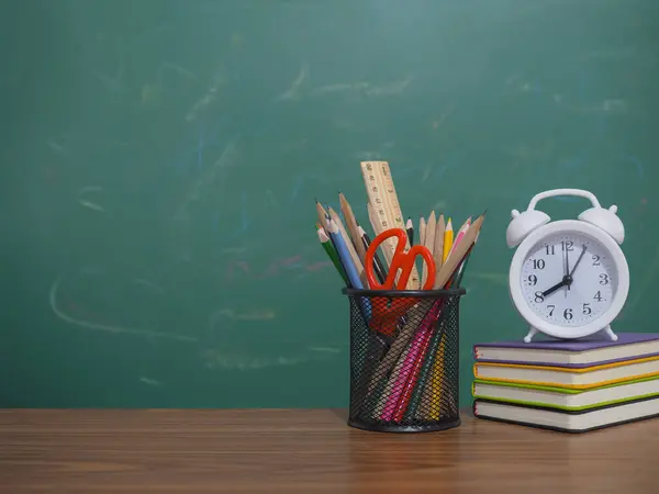 Hardcover kitabı ve renkli kırtasiyesinde beyaz alarmı olan yaratıcı öğrenci masaüstü. Metin için boşluk kopyala, okula geri dön, eğitim kavramı