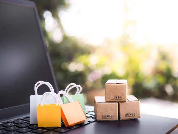 Shopping bags and boxes on a laptop keyboard. The concepts about Business E-Commerce and online shopping that offers home delivery