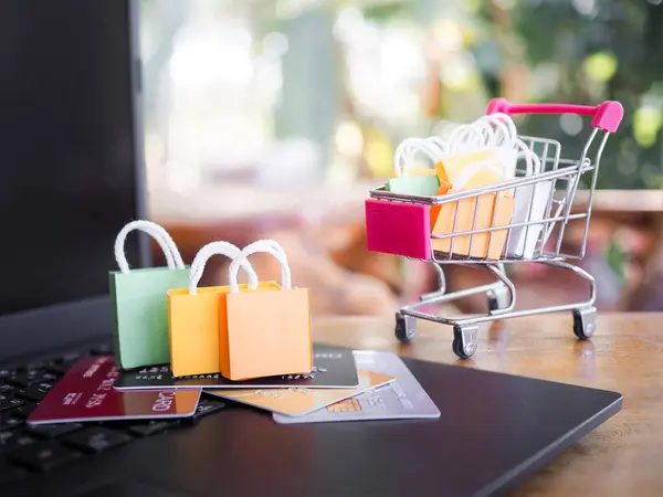 Alışveriş torbaları ve kredi kartları bir dizüstü bilgisayarın klavyesinde içinde alışveriş poşetleri olan. İş E-Ticaret ve çevrimiçi alışveriş konseptleri ev teslimatı sunuyor