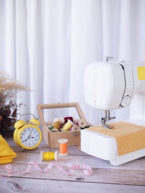Sarı kumaşla çalışan dikiş makinesi, masaya aksesuar dikmek, yeni kıyafetler dikmek..