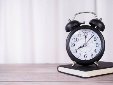 Arka planda beyaz perde olan ciltli kitaptaki siyah alarm. Metin için boşluk kopyala, Ofis masası kavramı.