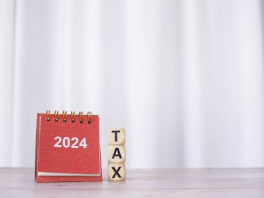 2024 desk calendar and Wooden blocks with the word TAX. The concept about prepare to pay tax in new year 2024 clipart