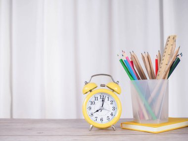 Öğrenci yaratıcı masaüstü, sarı alarm, ciltli kitap ve renkli kağıtlar. Metin için boşluk kopyala, okula geri dön, eğitim kavramı