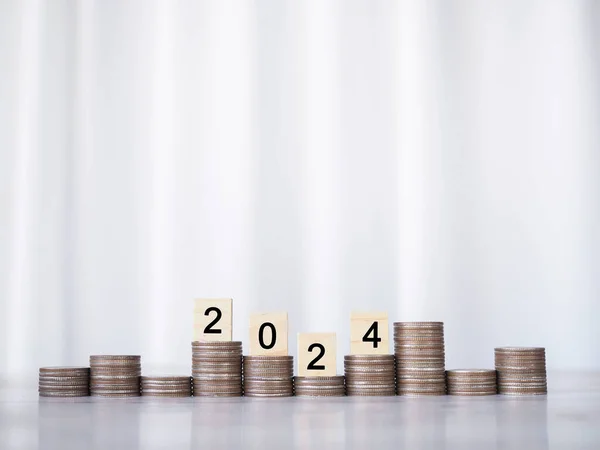 Tahta blok, 2024 numaralı madeni para yığını. 2024 yılında para, finans, yatırım ve işletme tasarruf kavramı büyüyor.