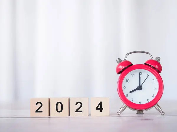 Red alarm and Wooden block with number 2024. The concept of manage time to success Financial, Investment and Business growing in new year 2024.