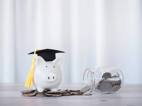 Piggy bank with graduation hat on stack of coins. The concept of saving money for education, student loan, scholarship, tuition fees