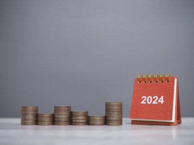 2024 masa takvimi ve bozuk para yığını. Finansal, Yatırım ve İşletme için para biriktirme kavramı 2024 yılında büyüyor.