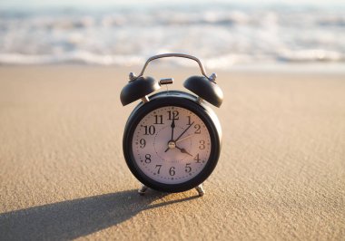 Gün batımında plajda siyah çalar saat. Yaz, Seyahat, Tatil ve Dinlenme Konsepti