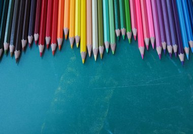 Kara tahta arka planında renkli kalemler