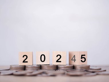 2024 'ten 2025' e kadar bozuk paraların üzerindeki tahta bloklarda yazı tura atmak. İş başarısı hedefi, Finansal, Yatırım ve İşletme için para biriktirme kavramı 2025 yılında büyüyor.