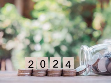 Tahta blok, 2024 numaralı madeni para yığını. 2024 yılında para, finans, yatırım ve işletme tasarruf kavramı büyüyor.