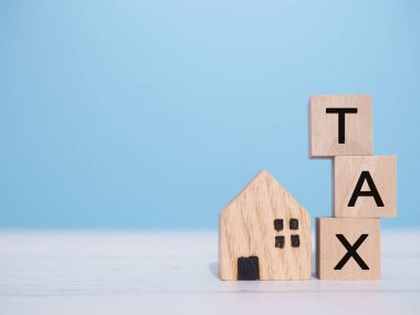 Minyatür ev ve tahtadan bloklar. Konut kredisi, emlak yatırımı, ev kredisi, emlak vergisi kavramı