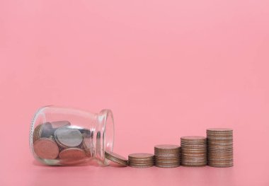 Cam şişe ve bozuk para yığını. Geleceğe hazırlık için para biriktirme kavramı.