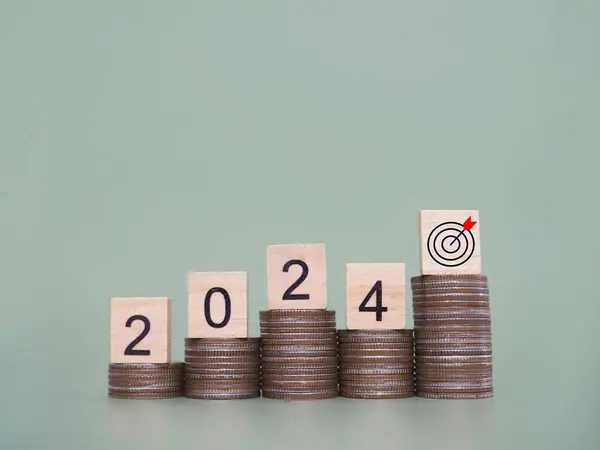 Wooden block with number 2024 on stack of coins. The concept of saving money for business achievement goal, Financial, Investment and Business growing in new year 2024.