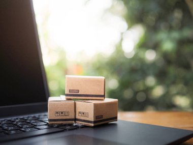 Laptop klavyesinde karton kutular. Ev teslimatı sunan online alışveriş konseptleri