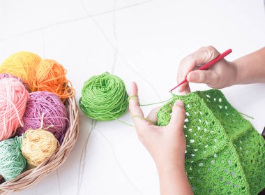 Yeşil yün örgü ören kadının yakın çekimi