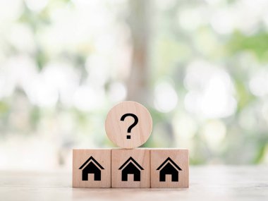 Soru işareti simgeli minyatür bir ev. Geleceği planlamak için uygun bir ev seçimi. Emlak