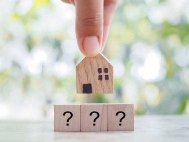 Soru işareti simgeli minyatür bir ev. Geleceği planlamak için uygun bir ev seçimi. Emlak