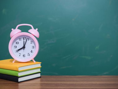Kapağında pembe alarm saati olan yaratıcı öğrenci masası. Metin için boşluk kopyala, okula geri dön, eğitim kavramı