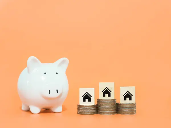 Piggy bank, Miniature house icons and stack of coins. The concept of saving money for house, manage time to Property investment, House mortgage, Real estate.