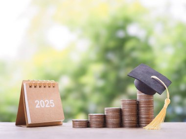 2025 masa takvimi ve mezuniyet şapkalı bozuk paralar. 2025 yılında eğitim, öğrenci kredisi, burs, öğrenim ücreti için para biriktirme kavramı