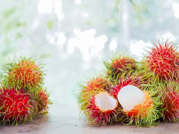 Ahşap masada yakın çekim olgun rambutanlar..