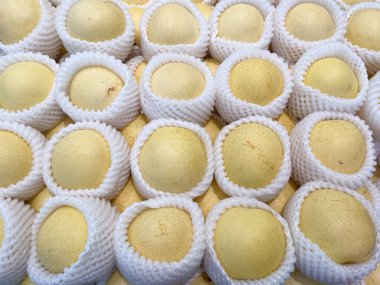 Süpermarkette satmak için beyaz ambalaj kağıdıyla sarılmış Çin armutlarını kapat