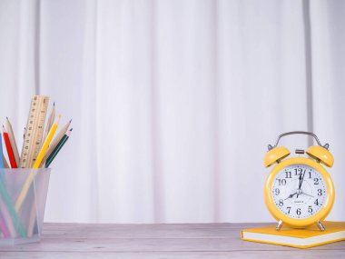 Yaratıcı masa, ciltli kitap üzerindeki sarı alarm ve renkli kağıtlar. Metin için boşluk kopyala, Ofis çalışma alanı kavramı.