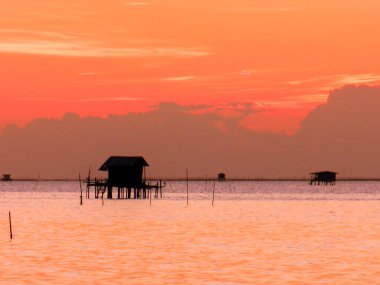 Gün batımında gölgeli balıkçı kulübesi